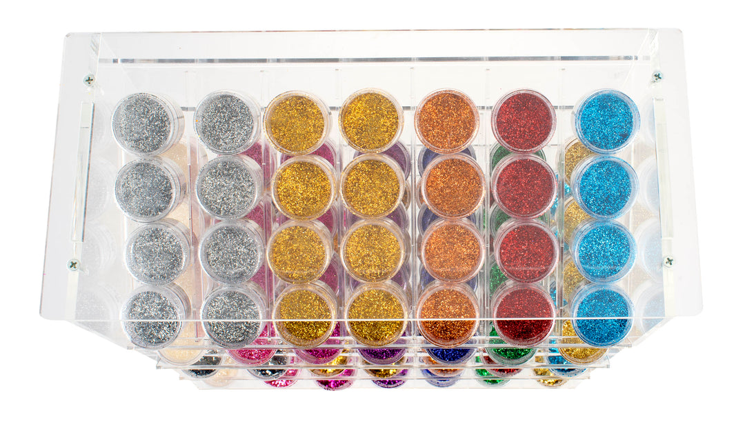 Die Draufsicht auf das Glorex Bio-Glitter Display 112tlg zeigt Reihen von kleinen Behältern mit buntem, umweltfreundlichem, biologisch abbaubarem Bio-Glitter in Silber-, Gold-, Orange-, Rot-, Blau- und Pink-Tönen.