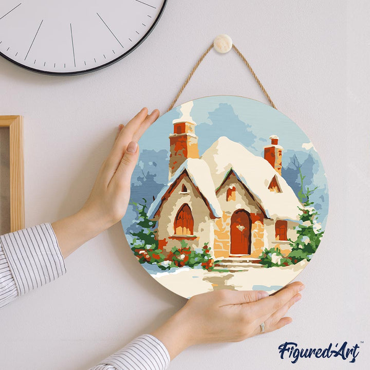 Malen nach Zahlen auf Holzscheibe – Backsteinhaus im Schnee