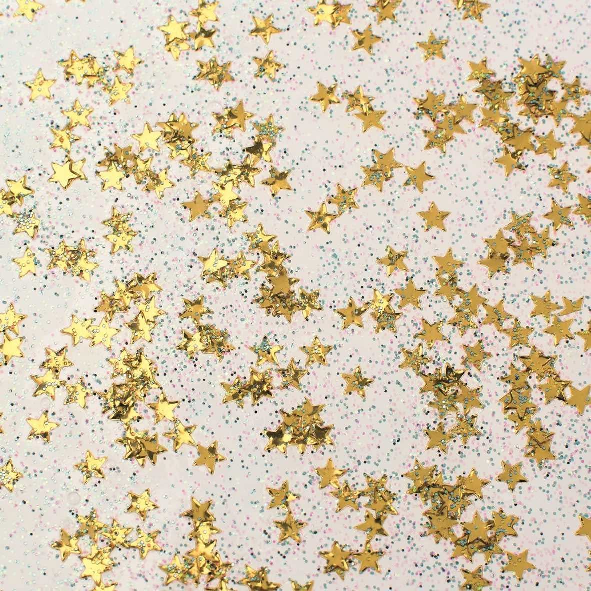 Gros plan d'un flacon de colle pailletée dorée "Confetti" avec étoiles métalliques et micro-paillettes
