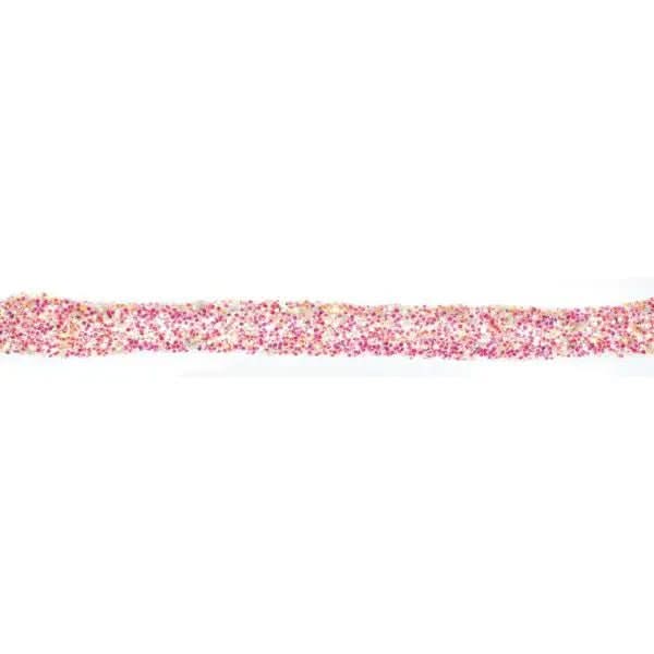 Nahaufnahme getrockneter Glitterkleber-Linie mit rosa-goldenem Glitzereffekt und körniger Textur auf weißem Untergrund