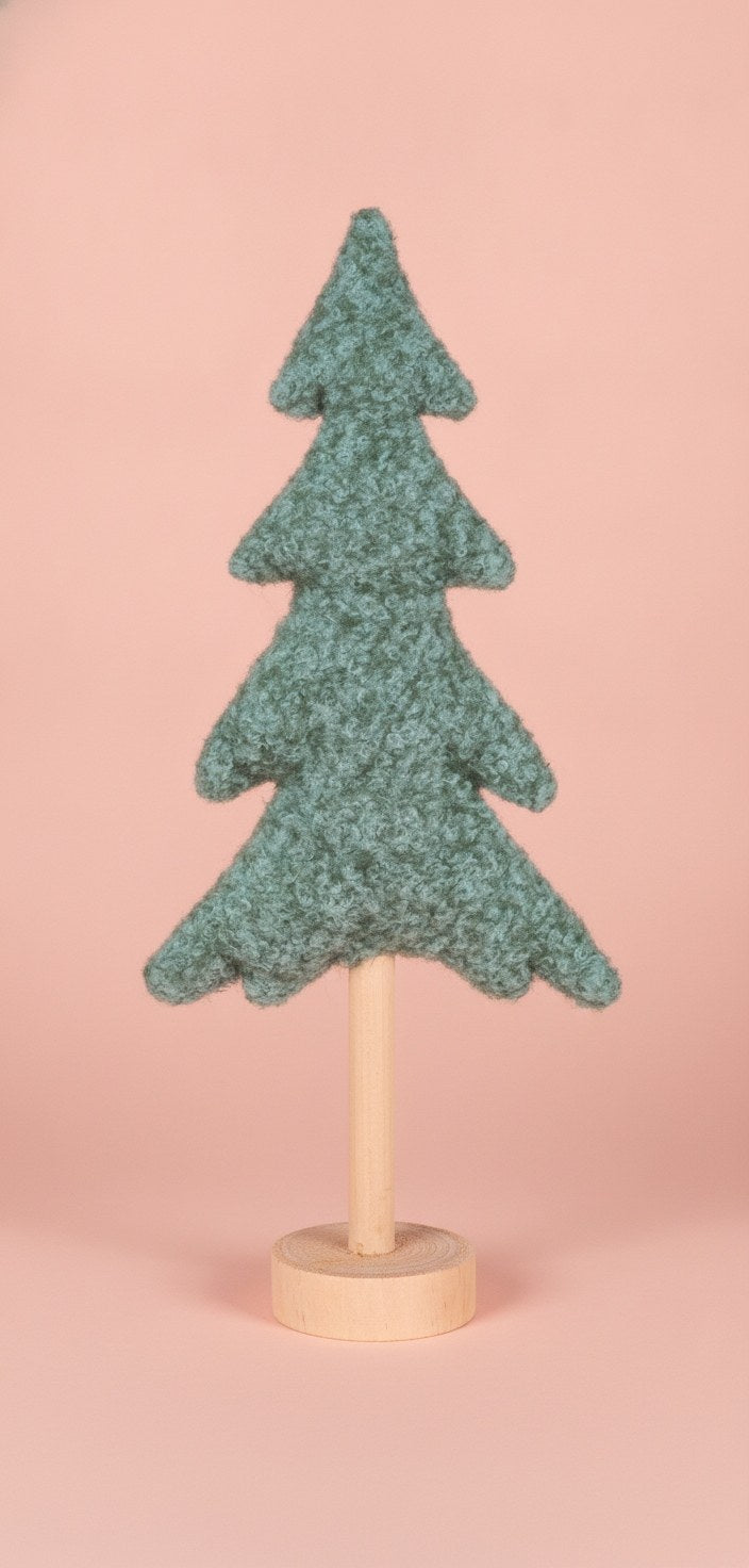Dreiviertelansicht grüner Weihnachtsbaum, Kontrast strukturiertes Plüschgewebe zu glatter Holzoberfläche